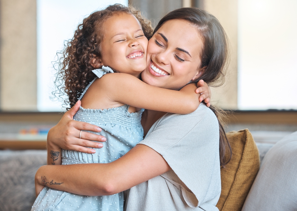 Hug, smile and mom on sofa with child